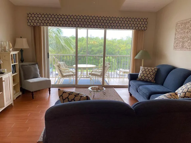 a living room with furniture and a floor to ceiling window