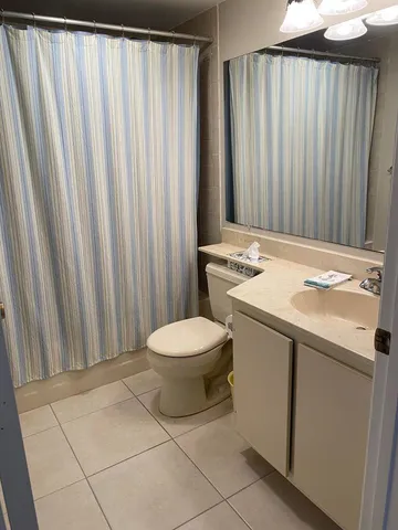 a bathroom with a granite countertop sink and a toilet