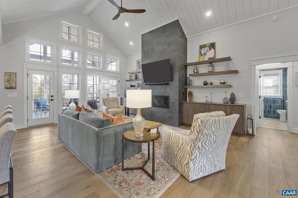 a living room with furniture a flat screen tv and kitchen view