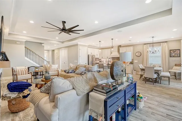 a kitchen with stainless steel appliances granite countertop a sink a stove a refrigerator and island with wooden floor