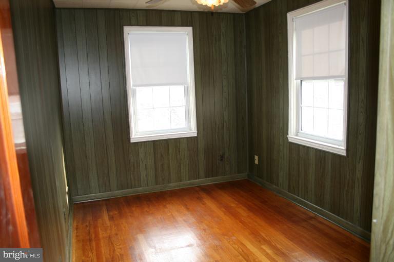 543 Larkfield Road Dundalk, MD 21222 - Photo 23 of 30 a view of an empty room with wooden floor and a window
