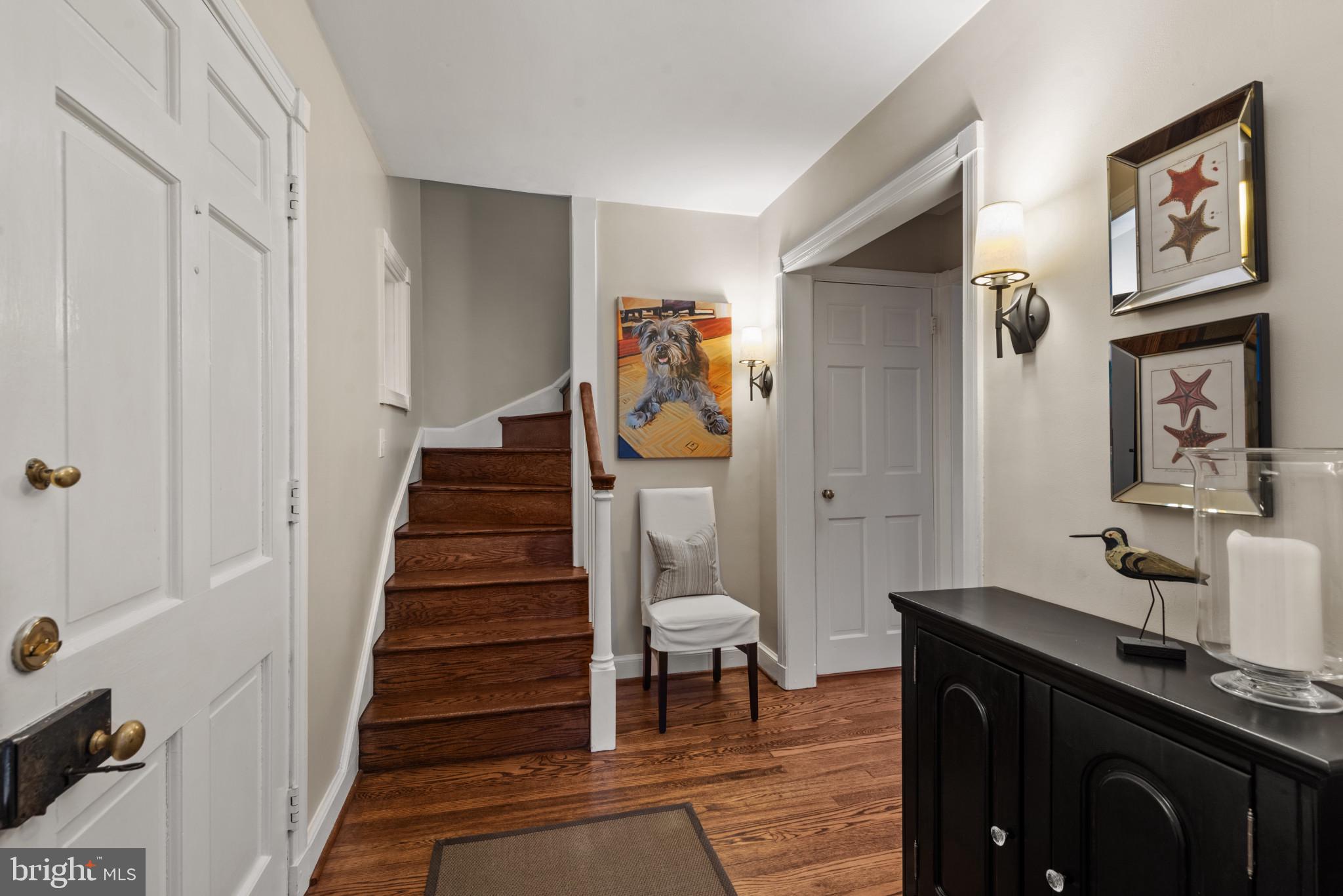 2443 Pickwick Road Baltimore, MD 21207 - Photo 27 of 108 a view of a hallway to a livingroom with wooden floor and furniture