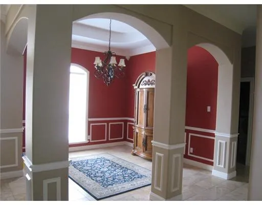 a view of a hallway with windows and chandelier