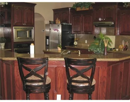 a kitchen with a refrigerator a stove and a wooden cabinets