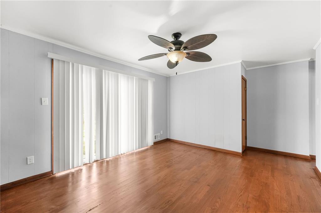 1393 Idlewood Road Tucker, GA 30084 - Photo 13 of 32 an empty room with wooden floor fan and windows