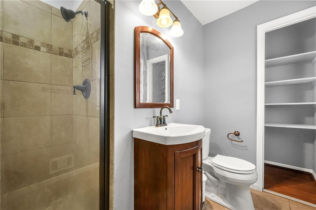 1393 Idlewood Road Tucker, GA 30084 - Photo 18 of 32 a bathroom with a toilet a sink a mirror and shower