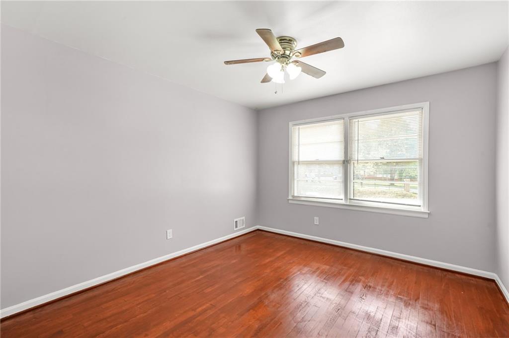 1393 Idlewood Road Tucker, GA 30084 - Photo 22 of 32 an empty room with wooden floor windows and fan