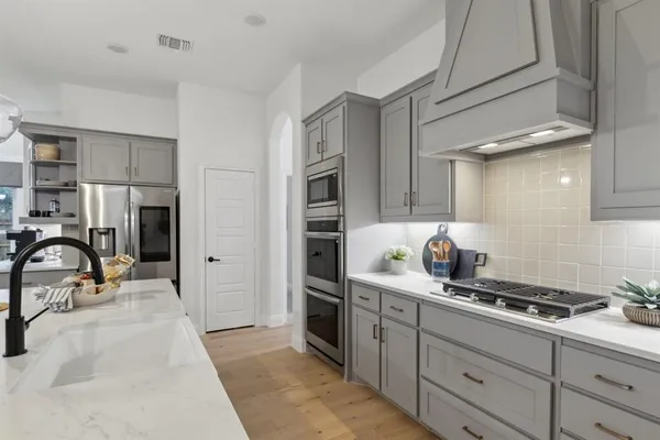 a kitchen with granite countertop a sink stainless steel appliances and cabinets
