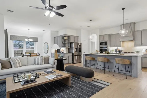 a living room with furniture kitchen view and a chandelier