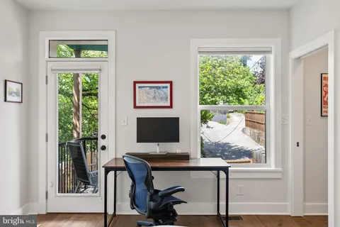 a view of a workspace with furniture and a window