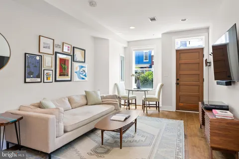 a living room with furniture a dining table and a flat screen tv