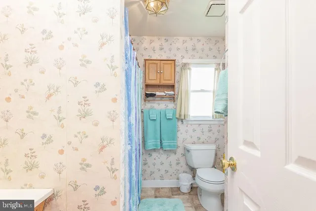 a bathroom with a granite countertop toilet a sink and a shower