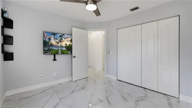 an empty room with windows and fan