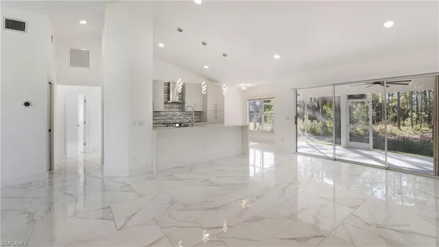 a view of a hall with kitchen and living room