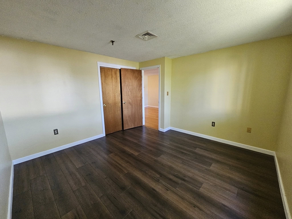 35 Prospect Street, Unit 215 Woburn, MA 01801 - Photo 11 of 37 a view of an empty room with wooden floor and a window