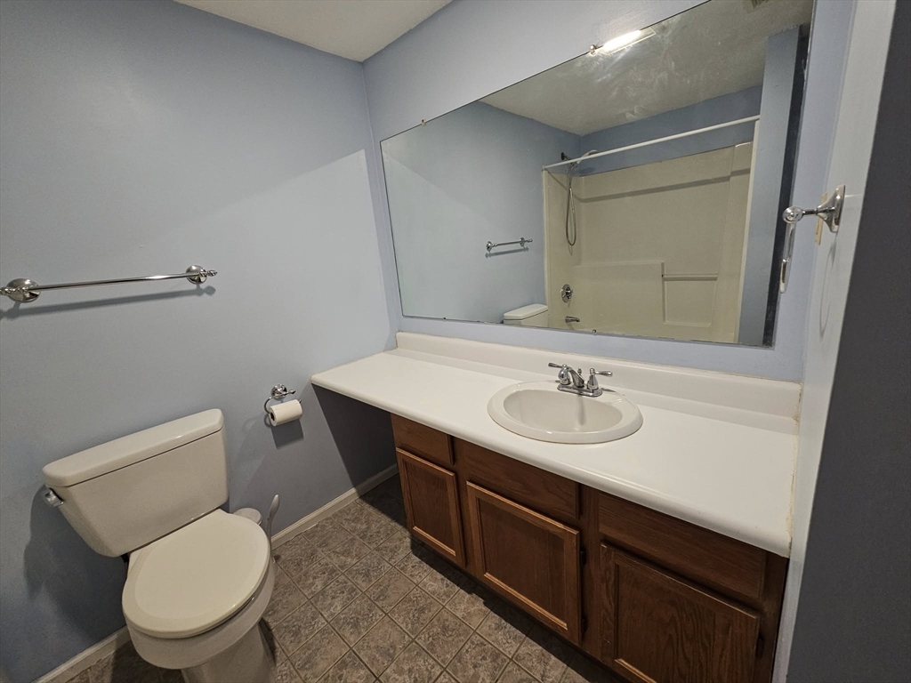 35 Prospect Street, Unit 215 Woburn, MA 01801 - Photo 13 of 37 a bathroom with a toilet a sink and mirror