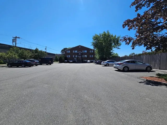 a front view of a house with cars parked