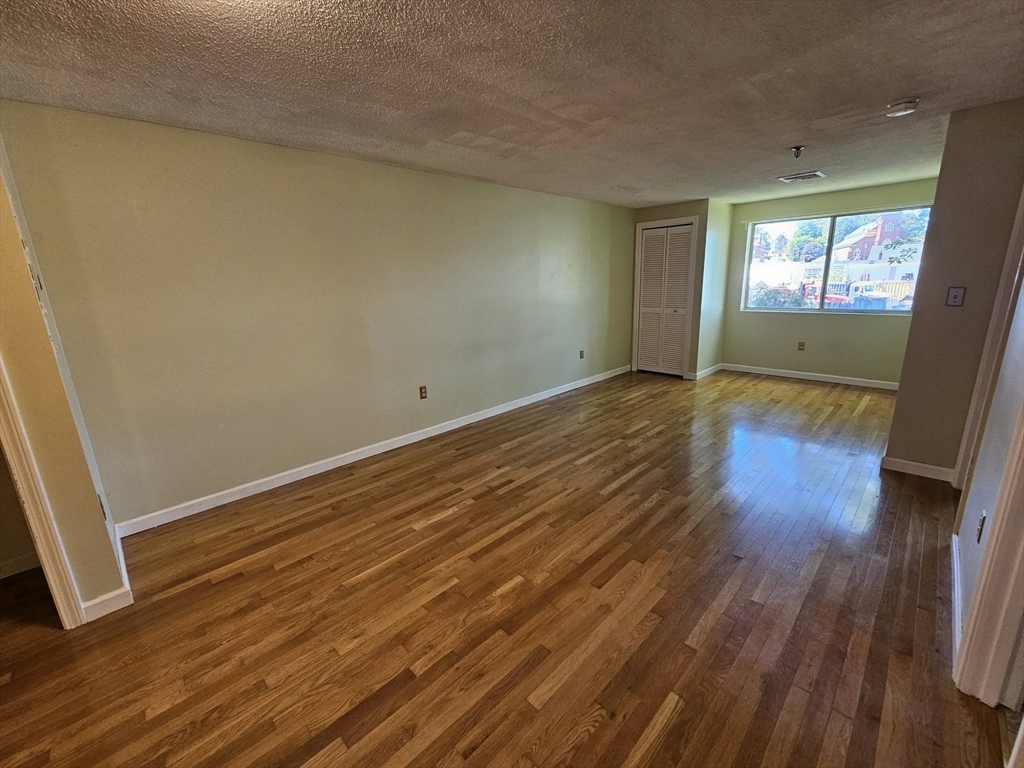 35 Prospect Street, Unit 215 Woburn, MA 01801 - Photo 5 of 37 a view of an empty room with wooden floor and a window
