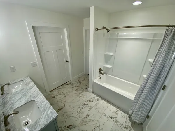 a bathroom with a tub a sink and a shower