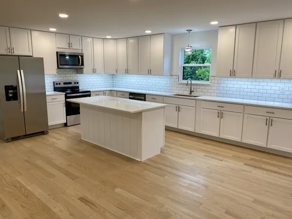 a kitchen with stainless steel appliances granite countertop a stove a sink and a refrigerator