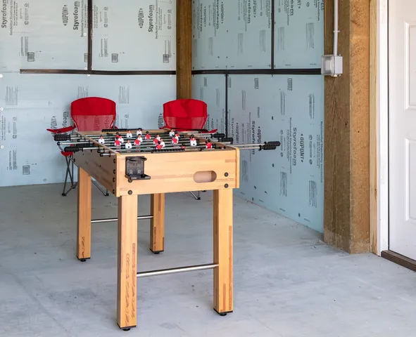 a tennis court with a table and chairs in front of it