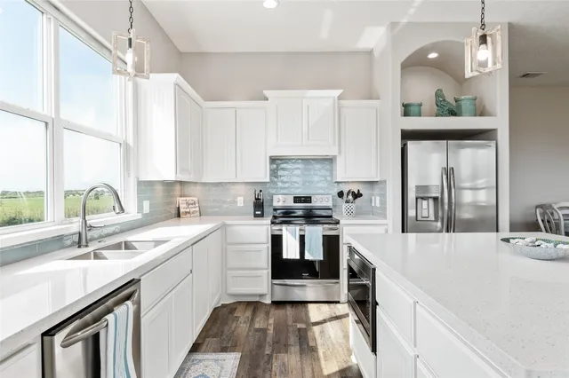 a kitchen with a sink cabinets appliances and a window