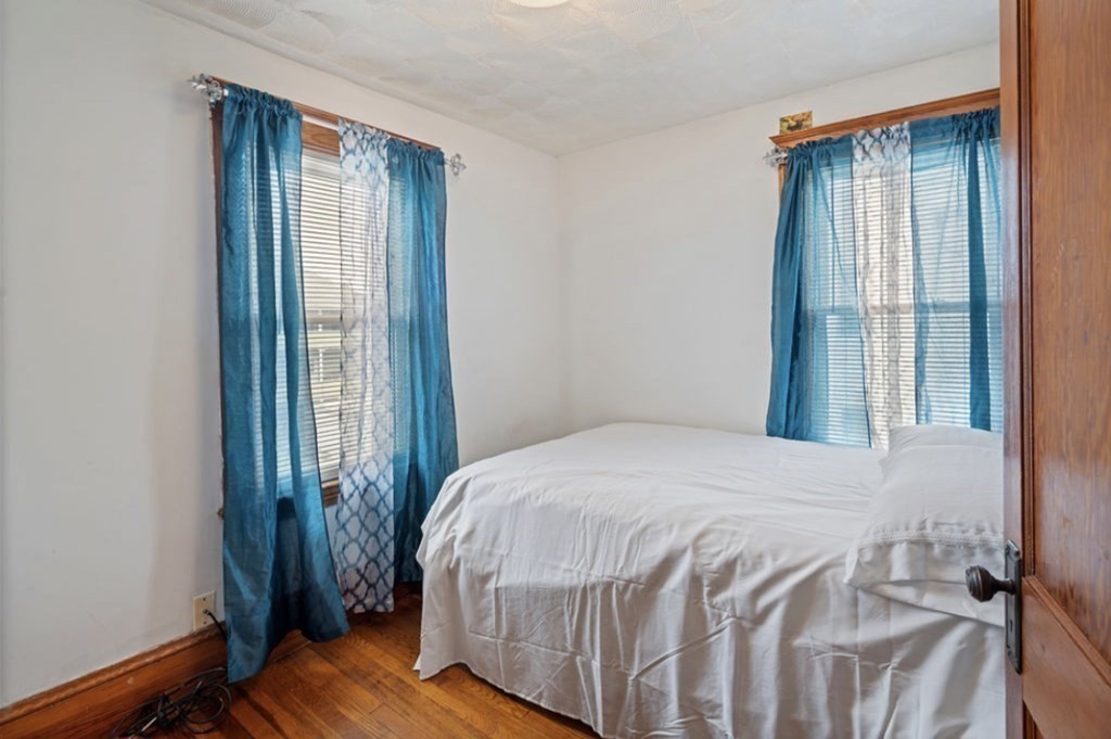 55 Austin Street Boston, MA 02136 - Photo 12 of 24 a bedroom with a bed and wooden floor