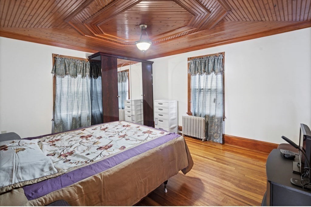 55 Austin Street Boston, MA 02136 - Photo 14 of 24 a bedroom with a bed and a chandelier