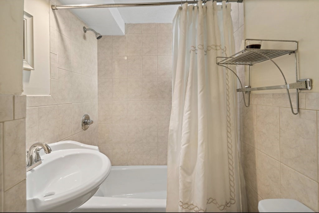 55 Austin Street Boston, MA 02136 - Photo 20 of 24 a bathroom with a sink and a shower curtain