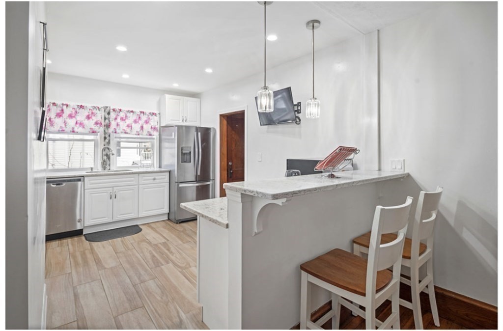 55 Austin Street Boston, MA 02136 - Photo 6 of 24 a kitchen with kitchen island a sink stainless steel appliances and cabinets
