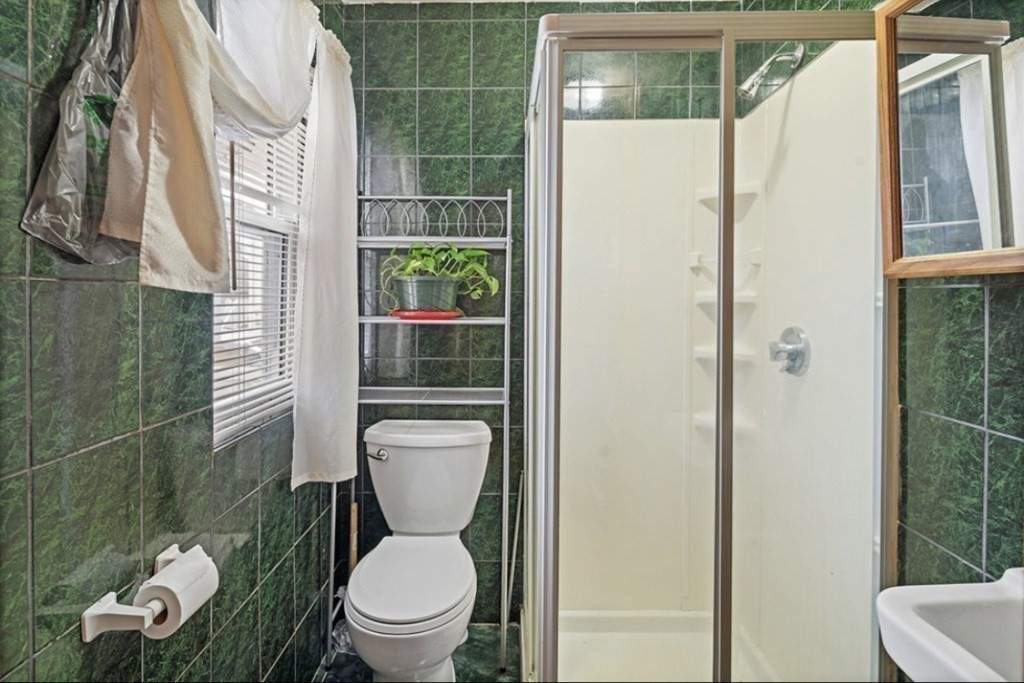 55 Austin Street Boston, MA 02136 - Photo 10 of 24 a white toilet sitting next to a bathroom sink