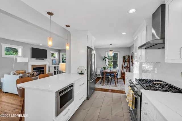 a kitchen with granite countertop a stove top oven a sink dishwasher a dining table and chairs with wooden floor