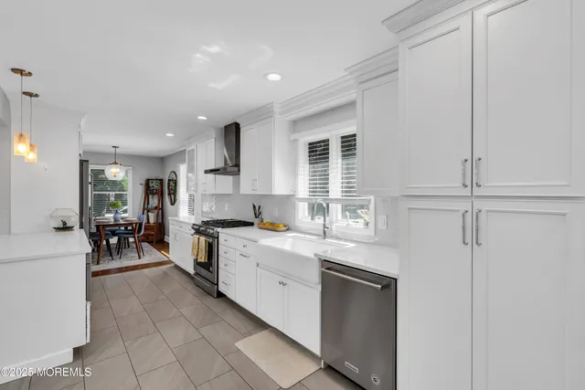 a kitchen with white cabinets and sink