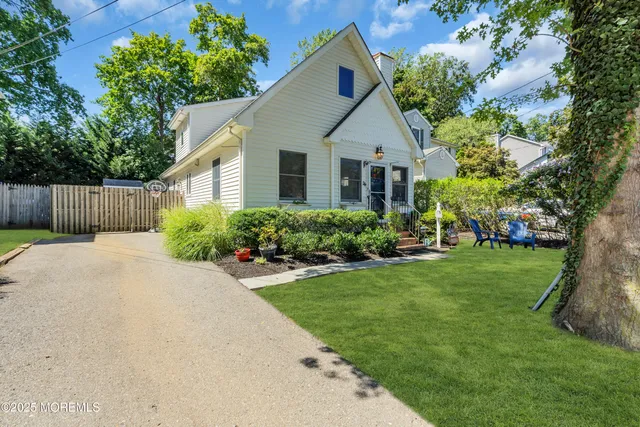 a front view of a house with a yard and trees