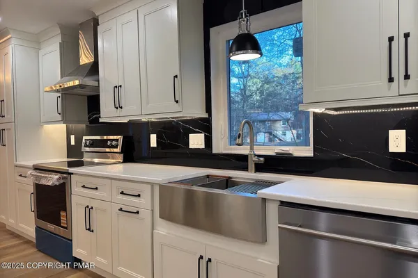 a kitchen with granite countertop white cabinets and appliances