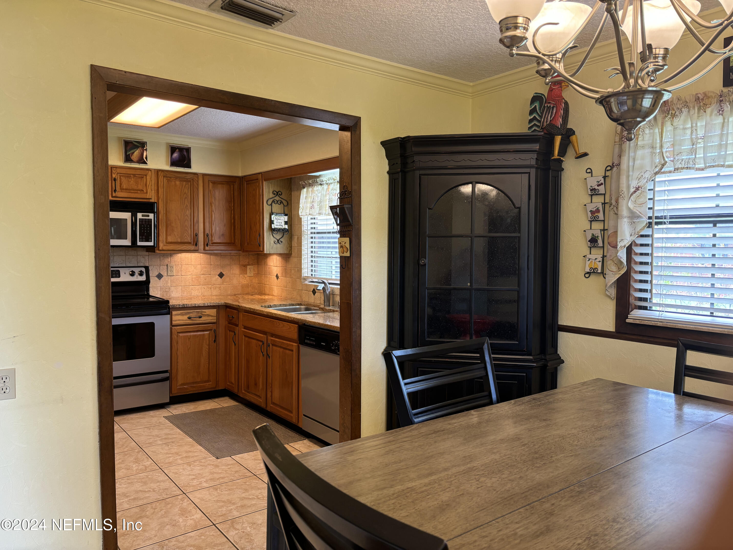 2700 New Berlin Road Jacksonville, FL 32226 - Photo 16 of 42 a kitchen with stainless steel appliances kitchen island granite countertop a refrigerator and a sink