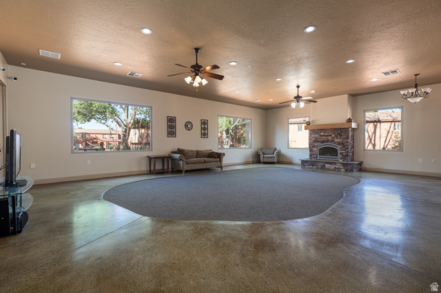 6 300th Road North, Unit I6 Kanab, UT 84741 - Photo 36 of 37 Living room featuring concrete flooring, a textured ceiling, plenty of natural light, a ceiling fan, and a fireplace