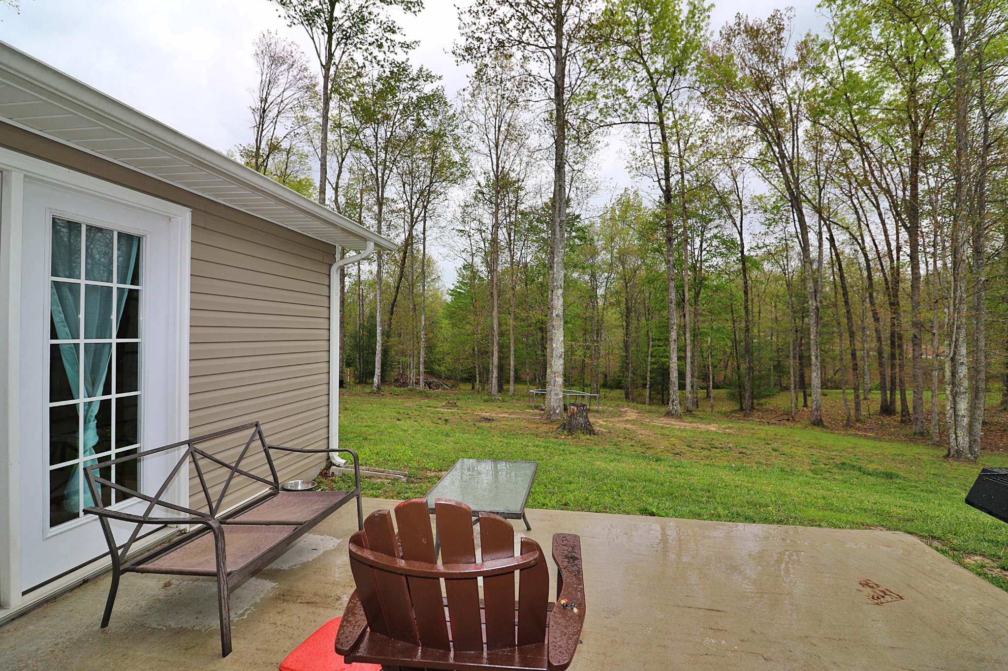 1110 Toomey Road Oneida, TN 37841 - Photo 14 of 30 a view of a backyard with table and chairs potted plants and large tree