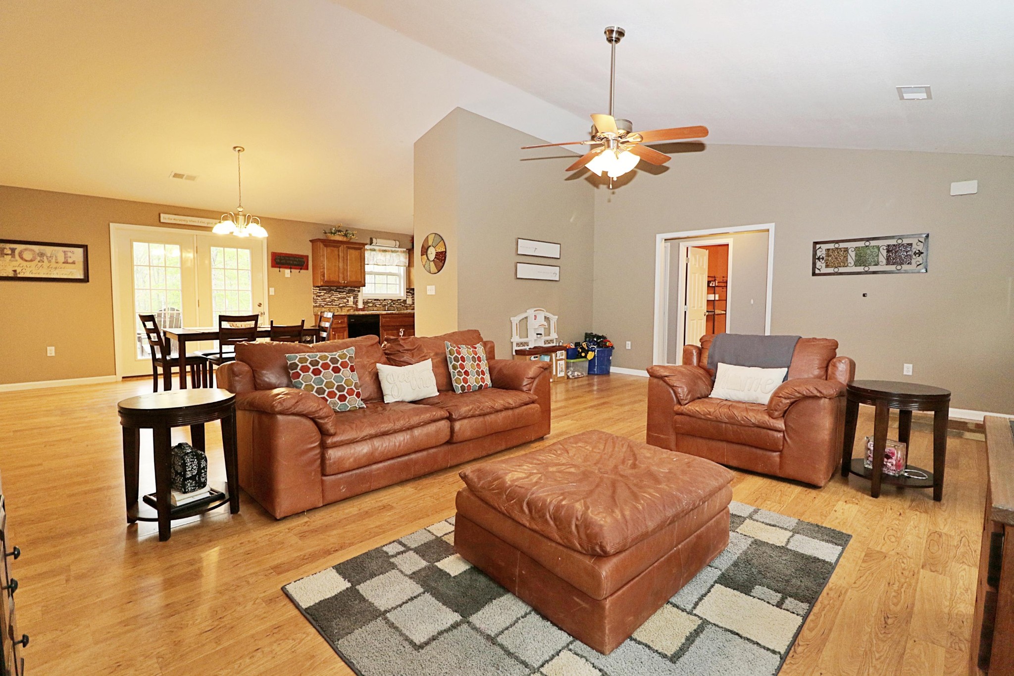 1110 Toomey Road Oneida, TN 37841 - Photo 7 of 30 a living room with couches a fireplace and a dining table with wooden floor