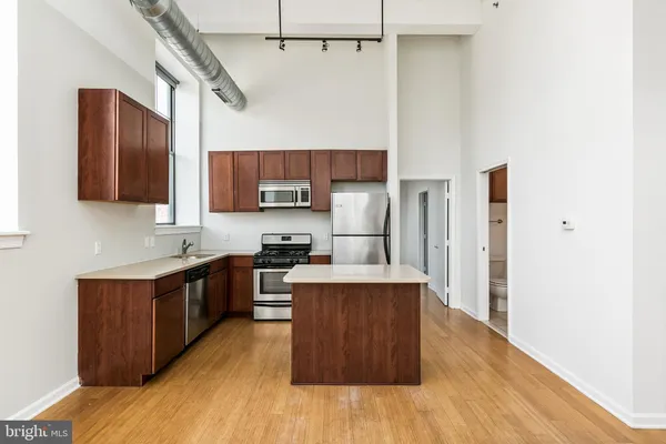a kitchen with stainless steel appliances a sink cabinets and wooden floor