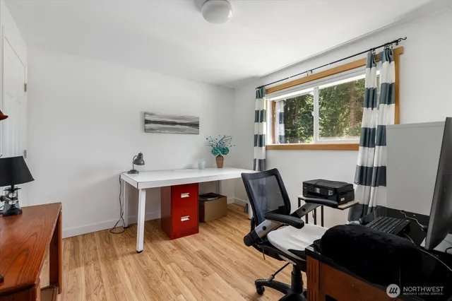 a view of a workspace with furniture and a window