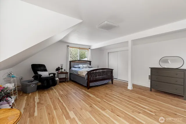 a bedroom with a bed and wooden floor