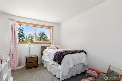 a bed sitting in a bedroom next to a window