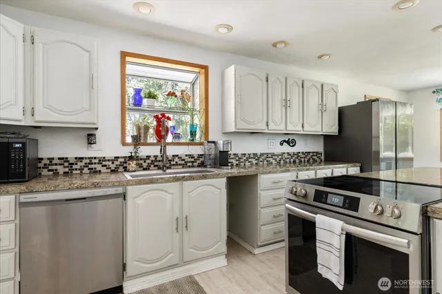 a kitchen with stainless steel appliances granite countertop a stove a sink and a refrigerator