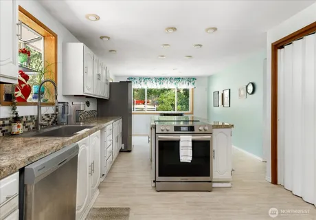 a kitchen with stainless steel appliances granite countertop a stove and a sink
