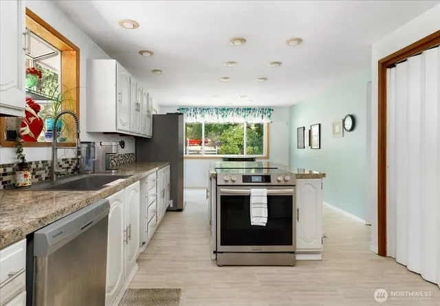 a kitchen with stainless steel appliances granite countertop a stove and a sink