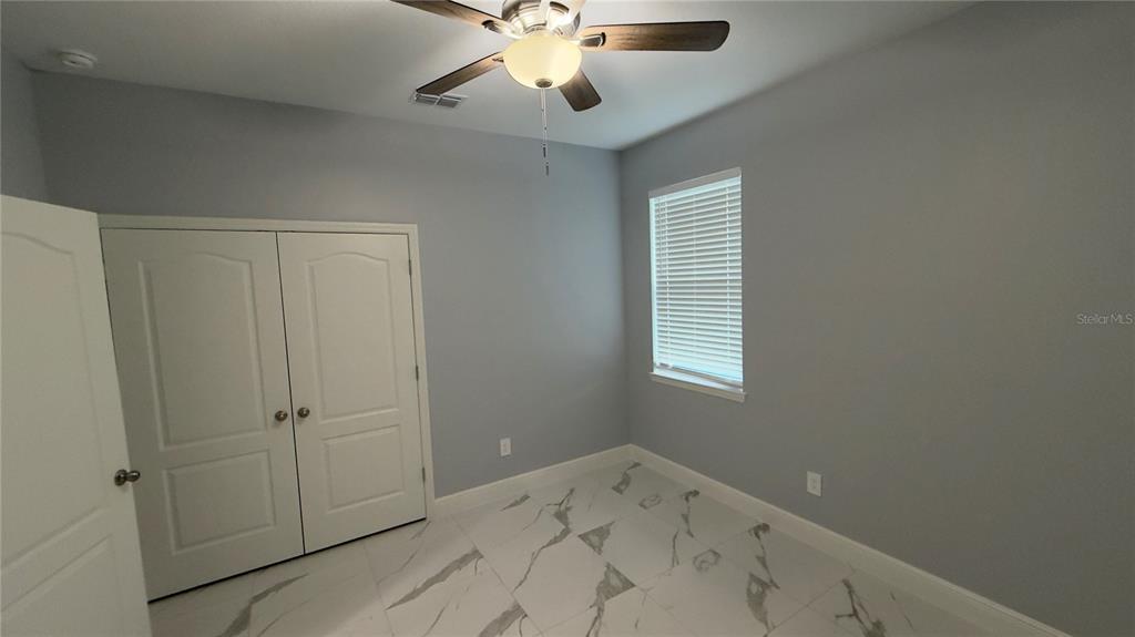 706 South Thacker Avenue Kissimmee, FL 34741 - Photo 11 of 36 wooden floor in an empty room with a window
