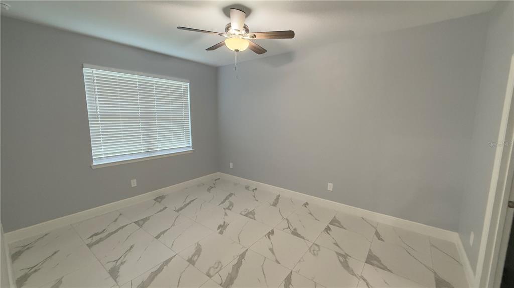 706 South Thacker Avenue Kissimmee, FL 34741 - Photo 12 of 36 an empty room with a window and a fan