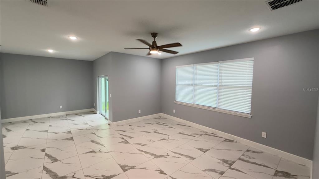 706 South Thacker Avenue Kissimmee, FL 34741 - Photo 13 of 36 a view of a livingroom with a chandelier fan and a window