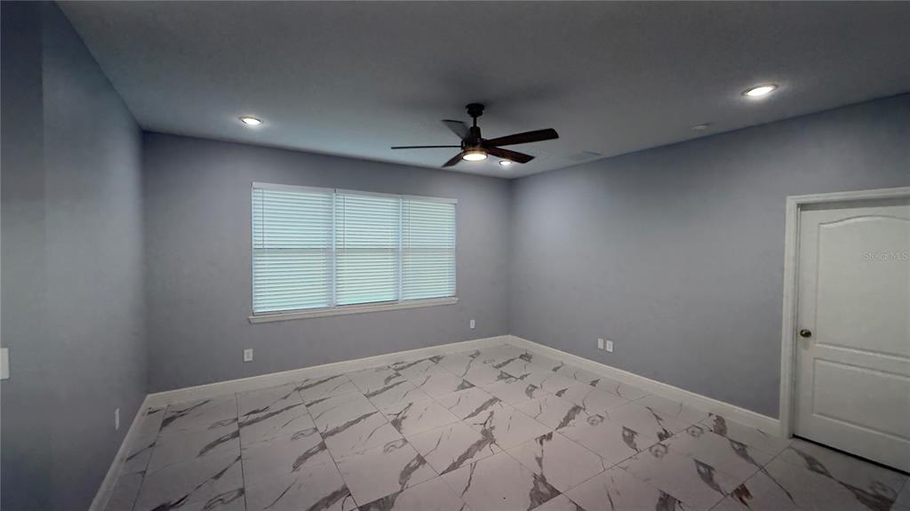 706 South Thacker Avenue Kissimmee, FL 34741 - Photo 14 of 36 a view of a livingroom with a ceiling fan and window